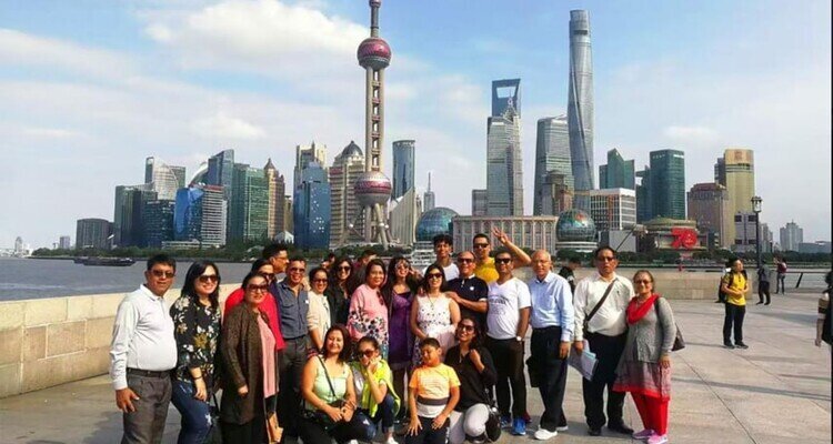 Visitors gather on the Bund promenade with Shanghai's Lujiazui skyline across the Huangpu River