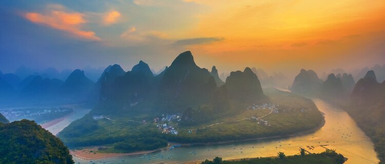 Matahari terbenam keemasan di atas sungai berliku dan puncak karst, dilihat dari Bukit Xianggong, Guangxi