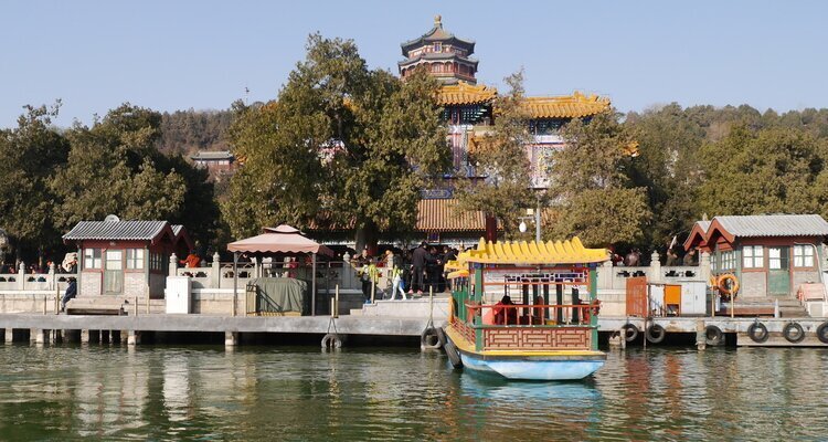 Sightseeing boat on Kunming Lake below wooded hills and palace roofs at Beijing's Summer Palace