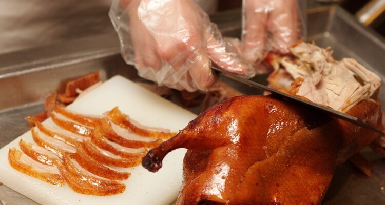 The chef is slicing the Peking duck.